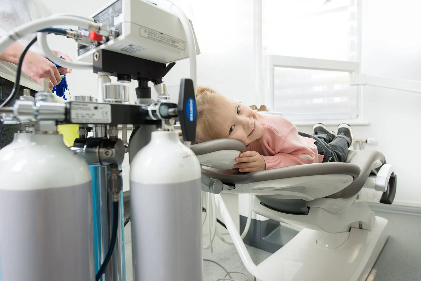 A child relaxed in the dental chair beside the nitrous oxide unit