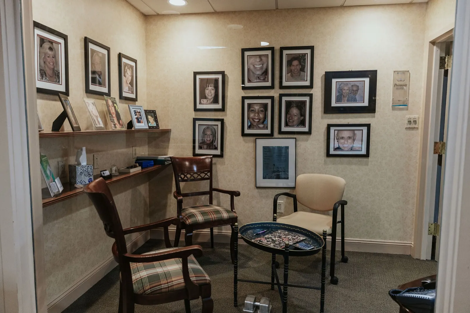 A consultation nook with framed photos of patient smiles