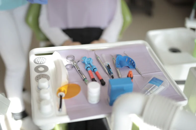 From above view of various modern medical instruments placed on tray near chair in modern room in clinic