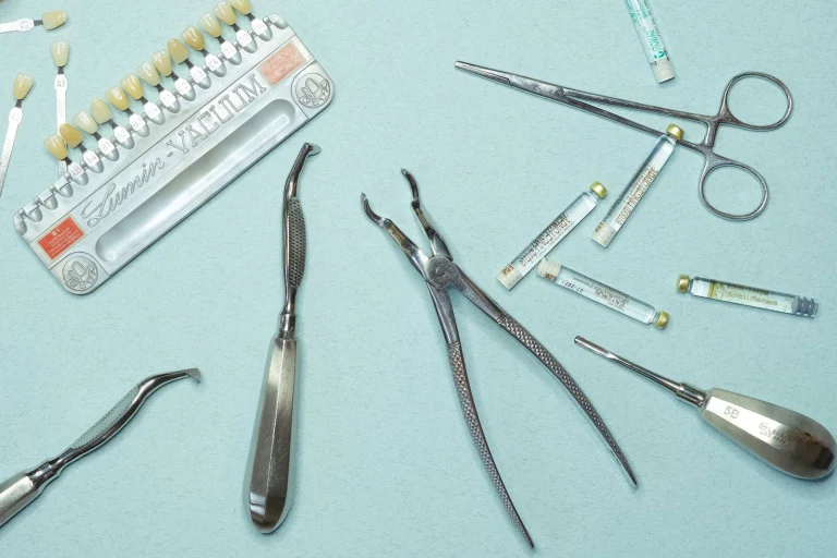 Overhead shot of various dental tools and materials arranged on a blue background.
