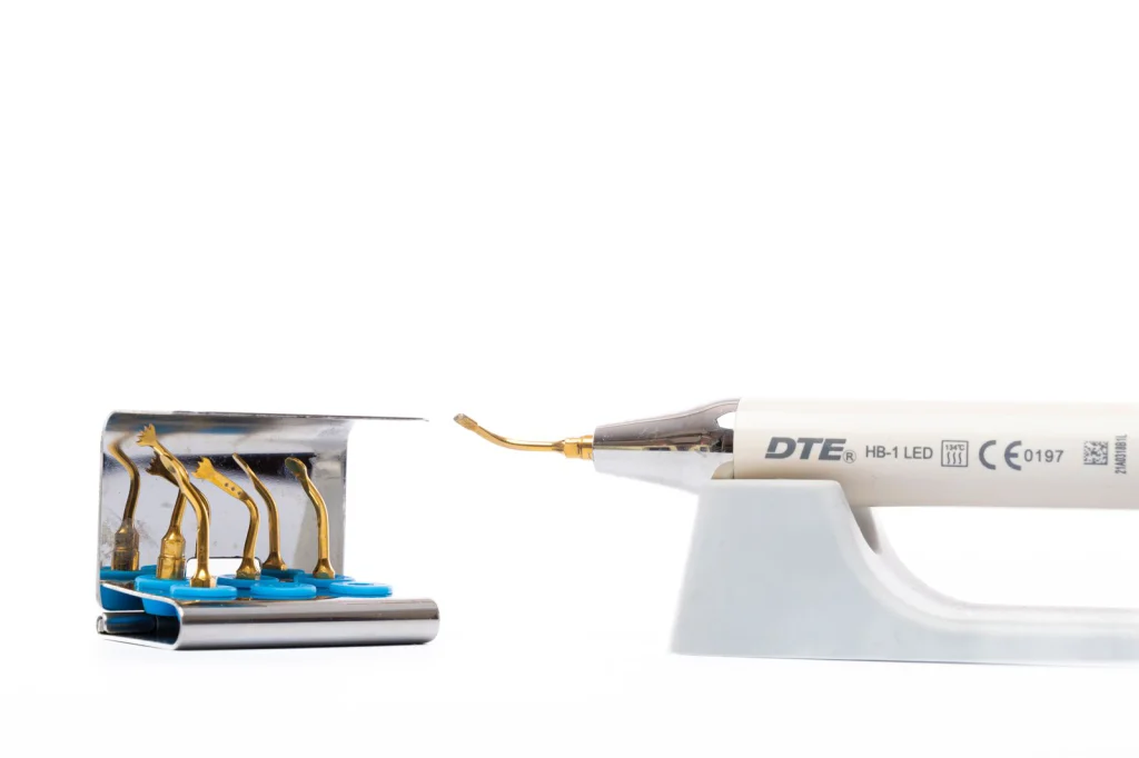 Close up of a dental ultrasonic scaler tool with multiple insert tips for dental hygiene.