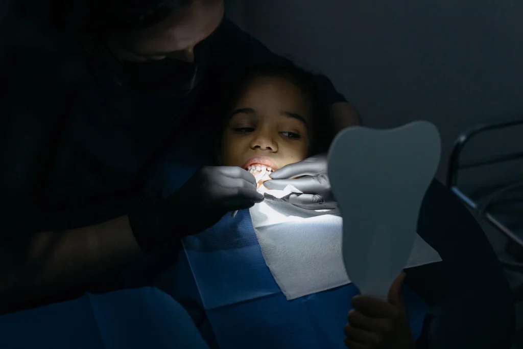 A child receives a dental checkup at a clinic, highlighting oral health care.