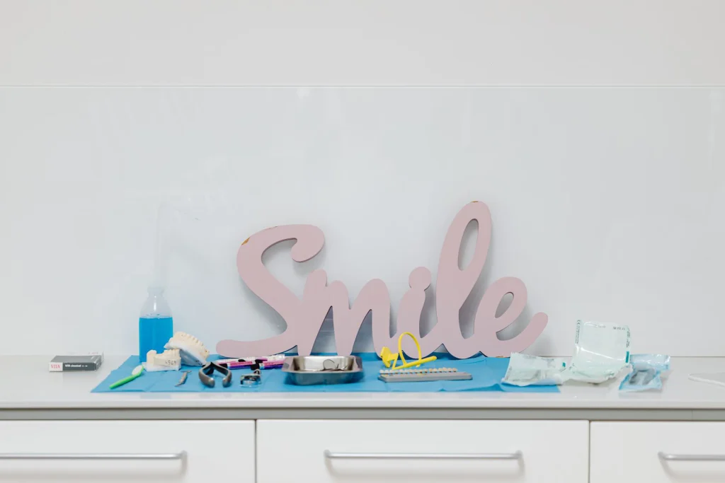 Dental tools and 'Smile' sign in a modern dental office setting, emphasizing oral health care.