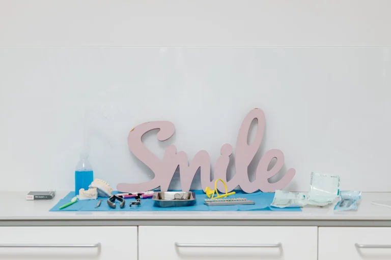 Dental tools and 'Smile' sign in a modern dental office setting, emphasizing oral health care.