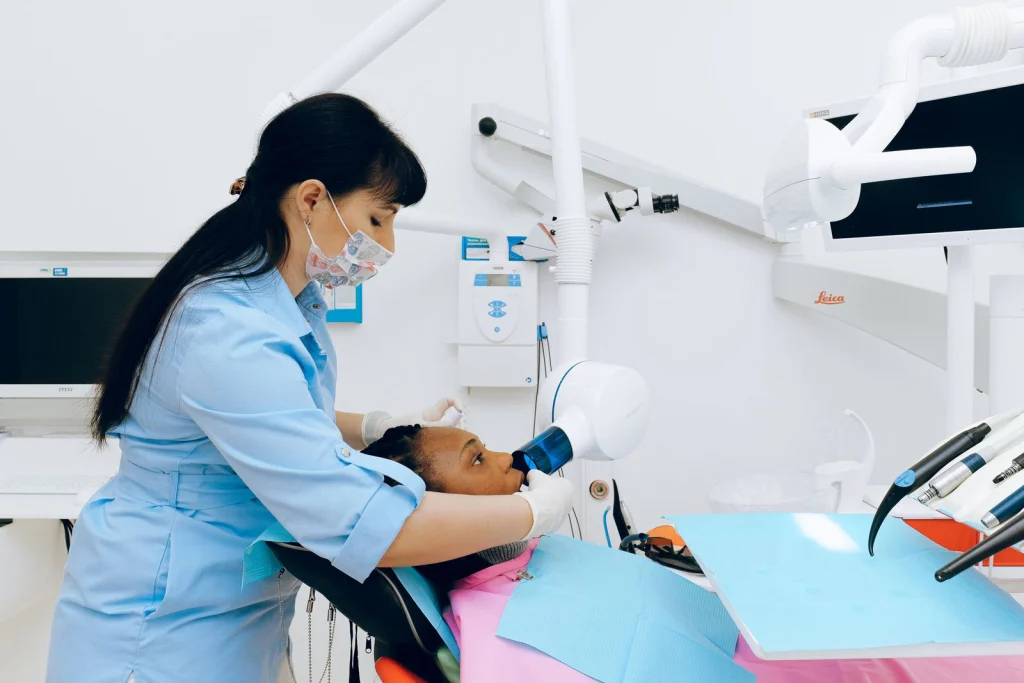 Dentist performs a dental procedure using advanced equipment in a modern clinic setting.