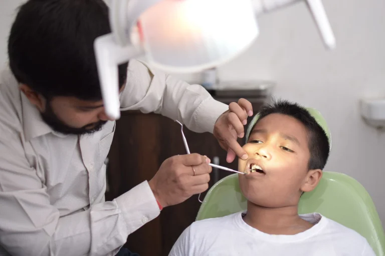 A dentist checks a child's teeth in a well-lit dental clinic, focusing on oral care.