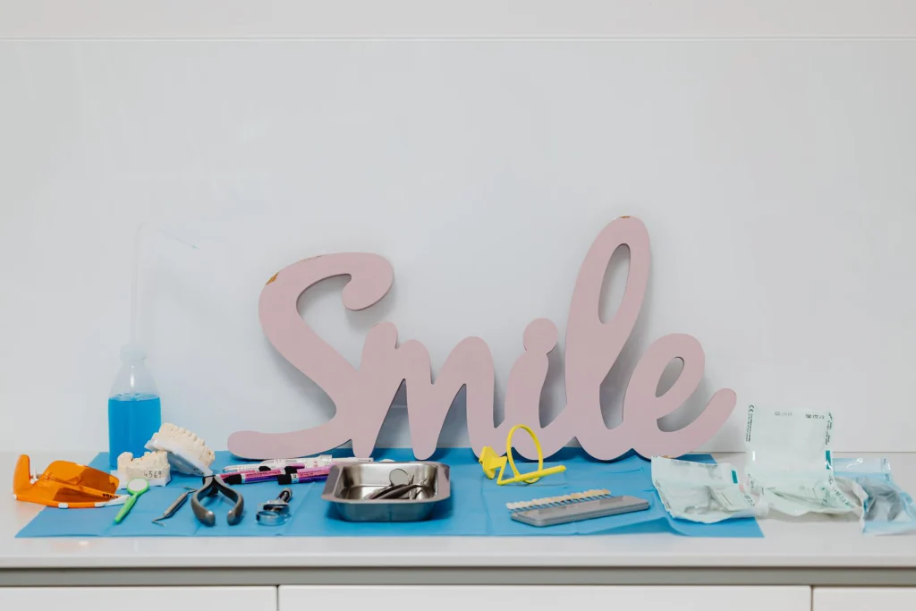 A collection of dental tools and a smile sign on a hygienic surface, ideal for healthcare concepts.