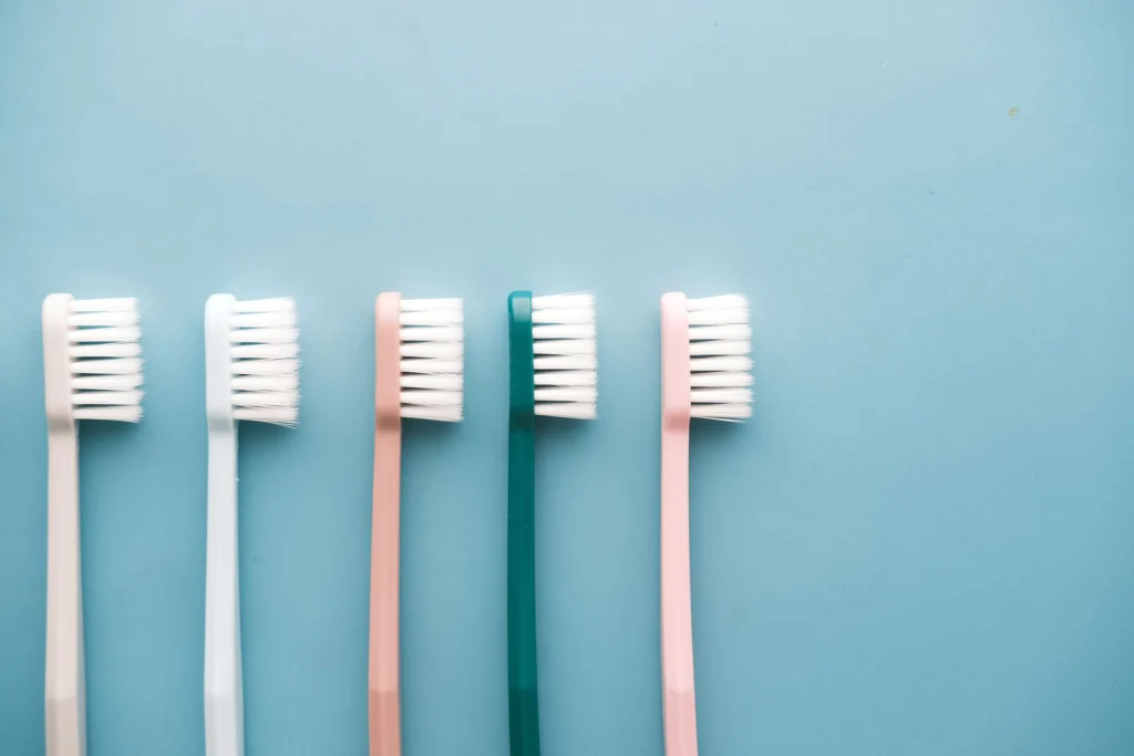 A row of five colorful toothbrushes arranged on a blue background, perfect for dental care themes.