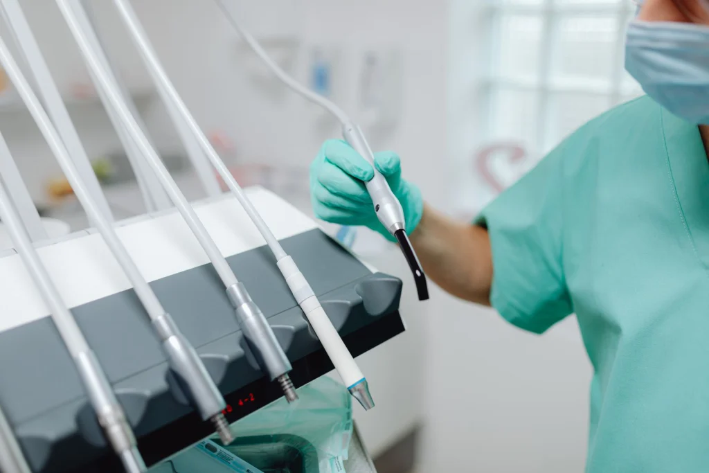Close-up of dental tools and equipment in a modern clinic with a dentist in scrubs.