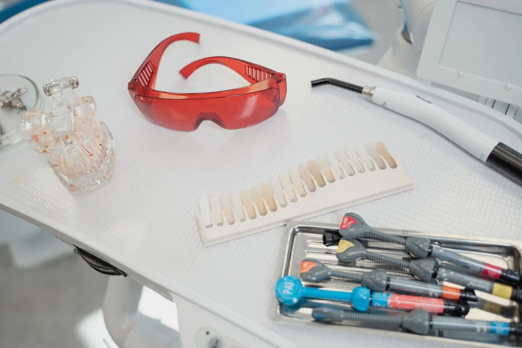 Close-up of dental tools and safety glasses on a white tray, ready for use.