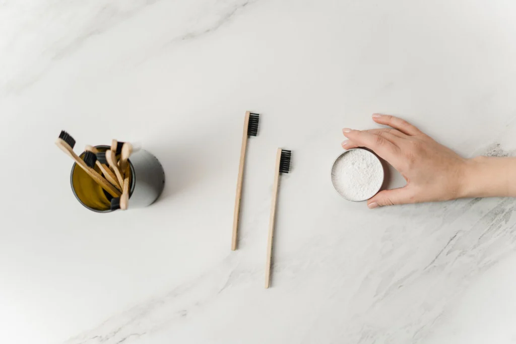 Flat lay of bamboo toothbrushes and eco-friendly dental powder emphasizing sustainable hygiene.