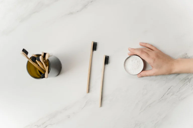 Flat lay of bamboo toothbrushes and eco-friendly dental powder emphasizing sustainable hygiene.