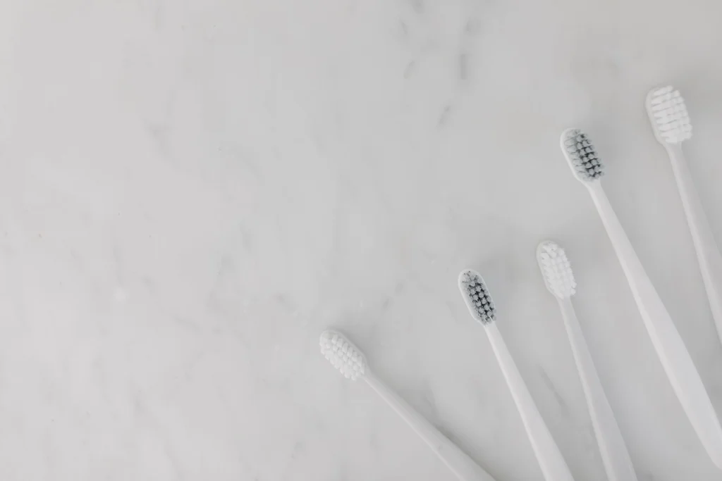 Elegant display of white toothbrushes on a marble surface, emphasizing hygiene and simplicity.